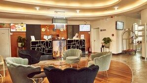 Un espace d’accueil moderne doté d’un plafond incurvé, d’un comptoir de réception et de différents espaces d’assise.