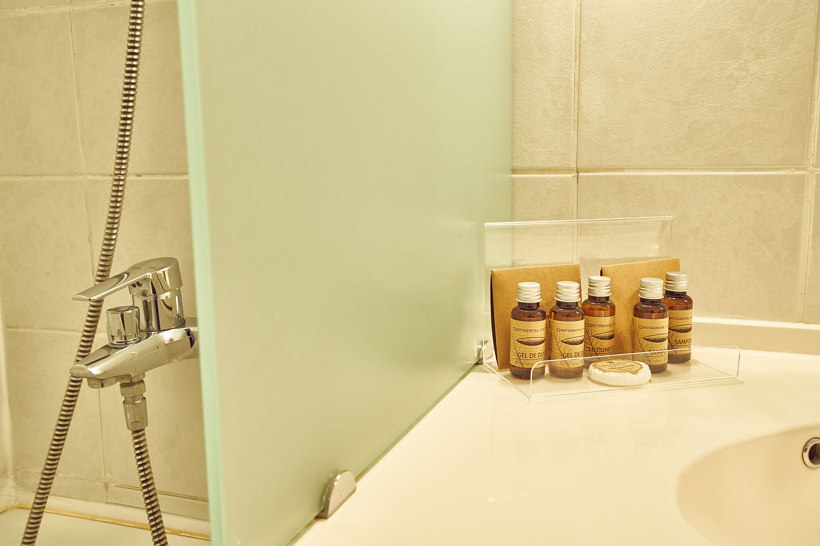 A bathroom with a shower, a bathtub, and a shelf with toiletries.