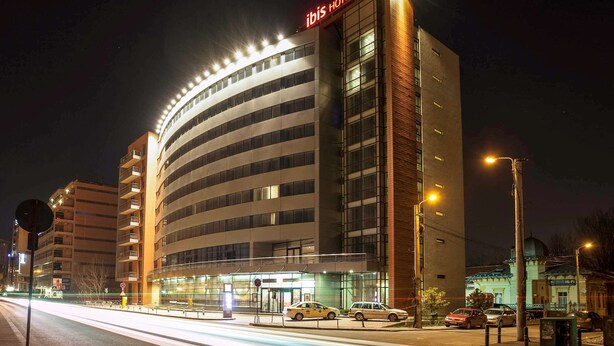 Un hôtel moderne à la façade incurvée, doté de plusieurs étages et d’une enseigne bien visible.