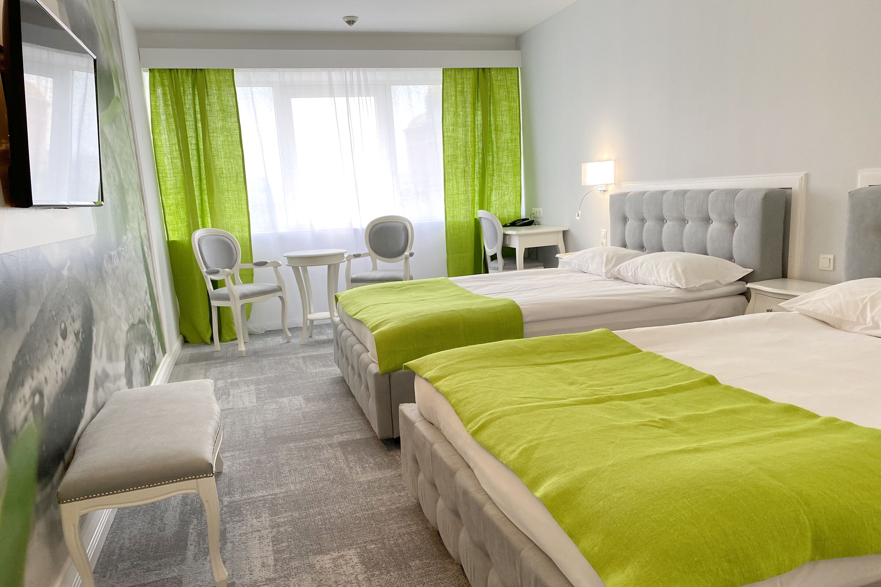 Una habitación de hotel con dos camas, un escritorio, una silla y una mesita.
