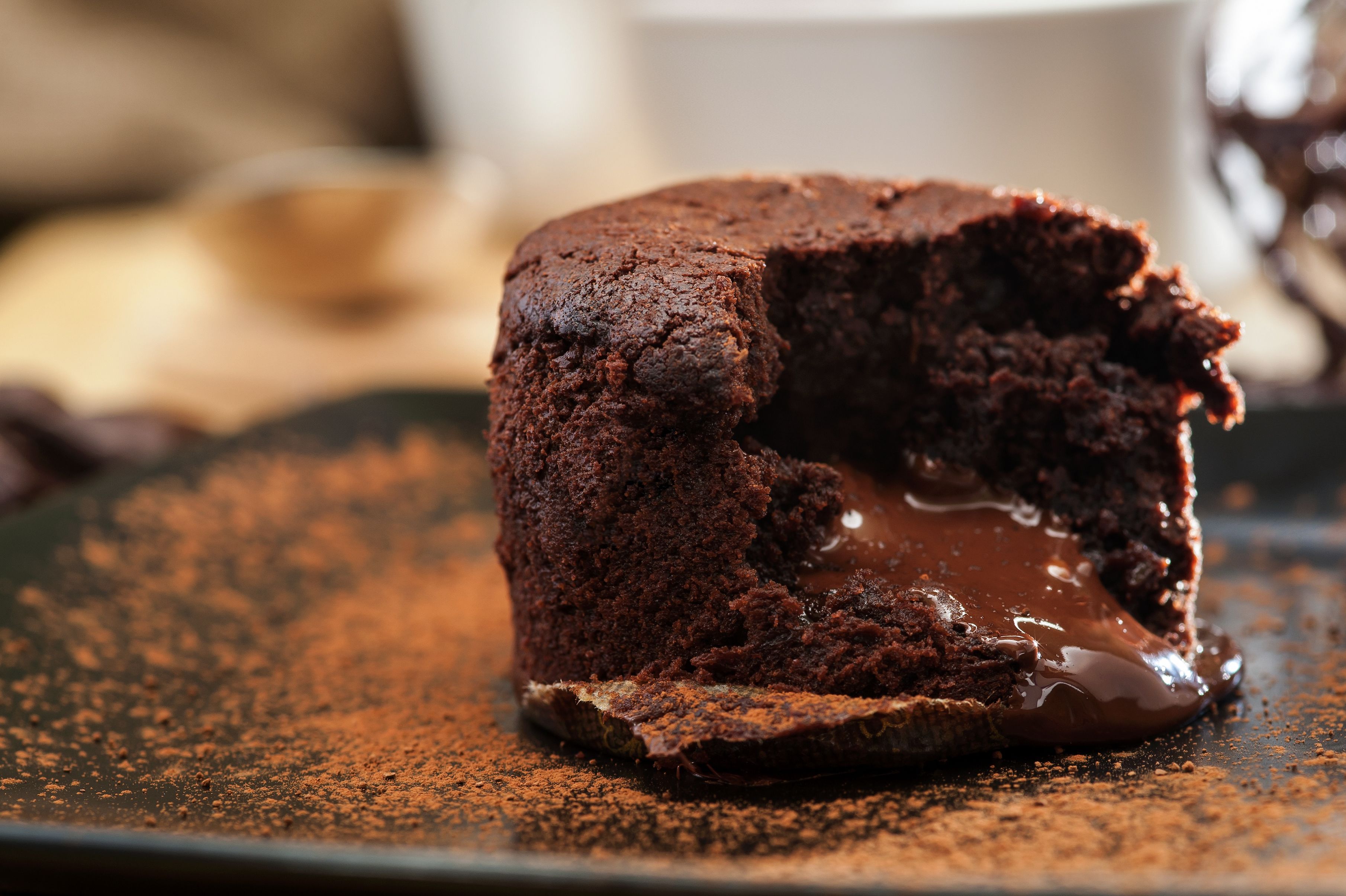 A chocolate lava cake with a glossy chocolate sauce on a plate.