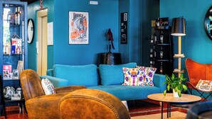A modern living room with a blue sofa, a brown leather chair, and a small round table with a plant.