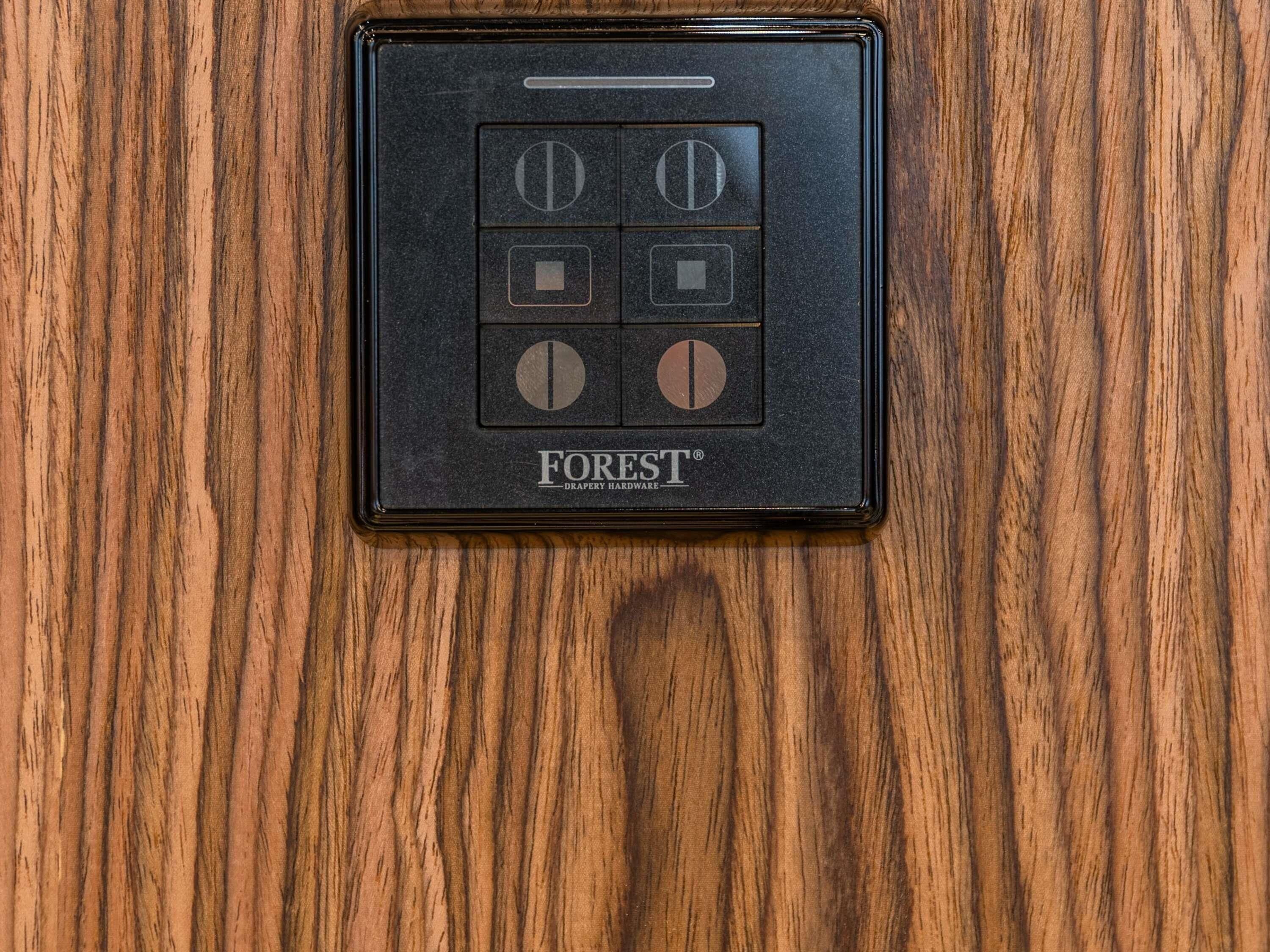 A black, rectangular, wooden-framed object with a grid of buttons and the 'FOREST' logo.