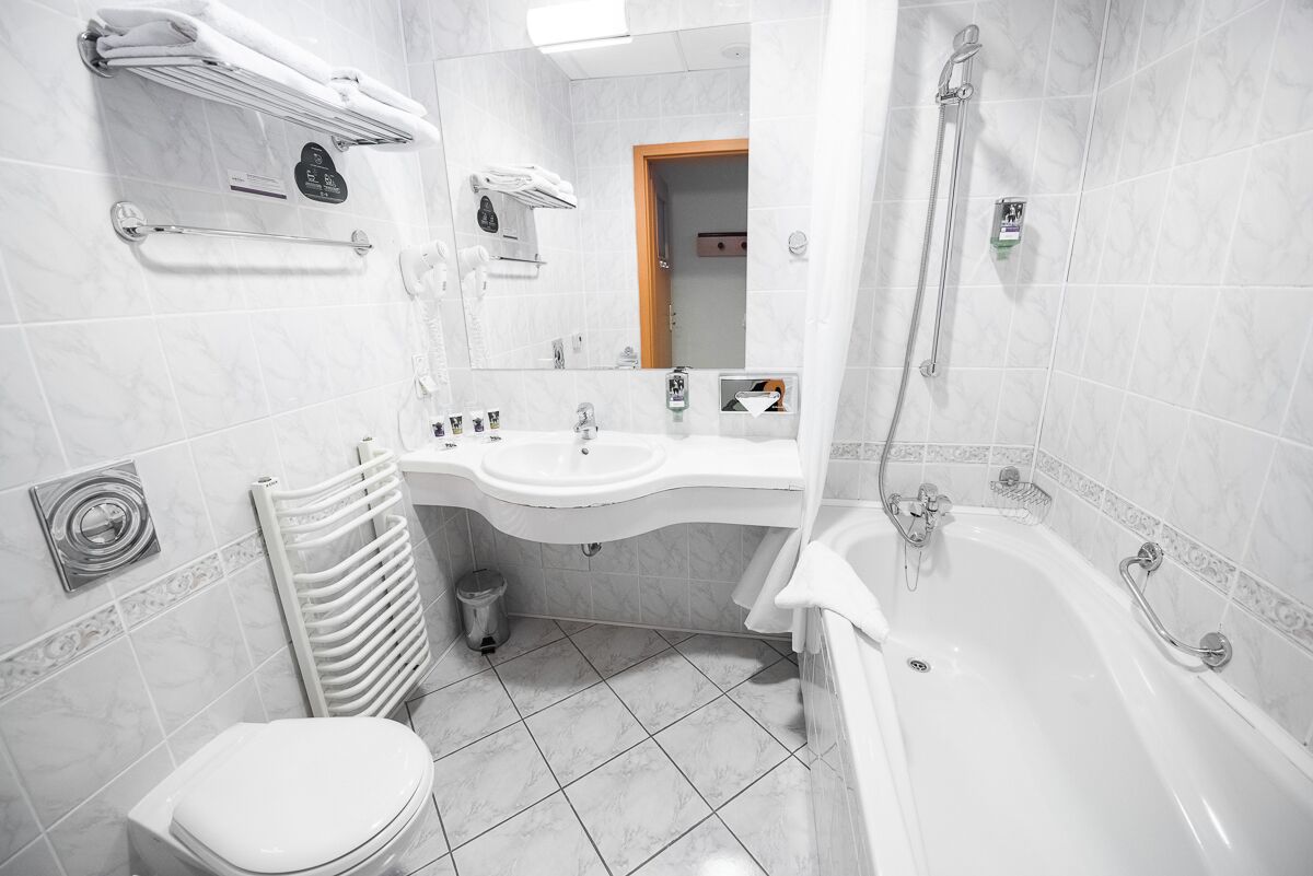 Uma casa de banho moderna com sanita, lavatório e banheira.