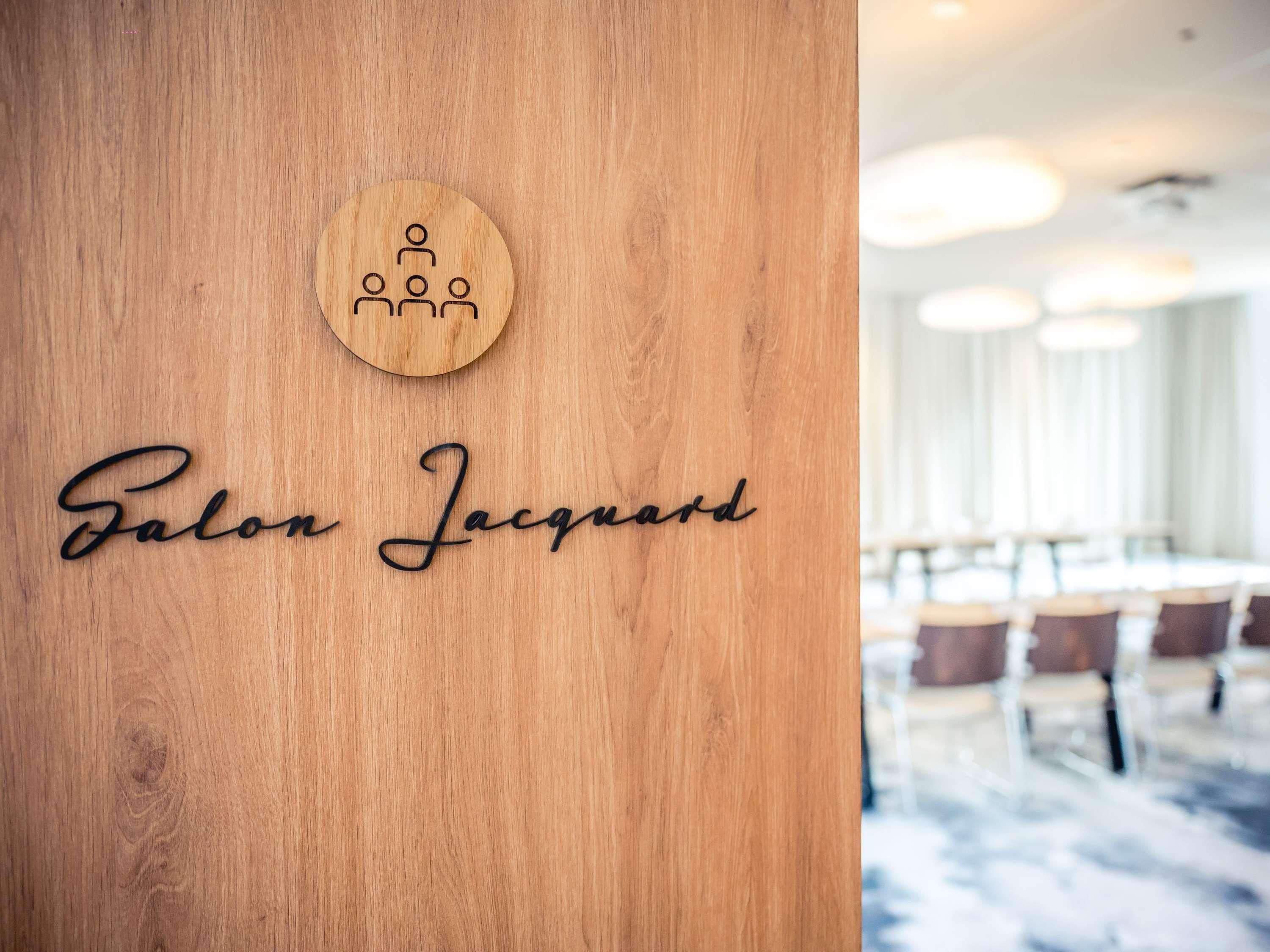 A wooden wall with a circular emblem and the name 'Salon Jacques' carved into it.