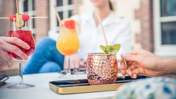 Un tavolo con bevande e uno smartphone.