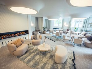 A modern living room with sofas, a coffee table, and a fireplace.