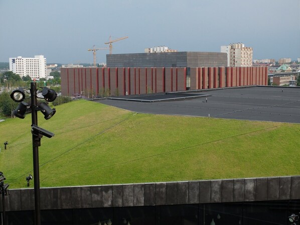 A building with a flat roof and a grassy area in front. - Novotel Katowice Centrum Hotel (Katowice)