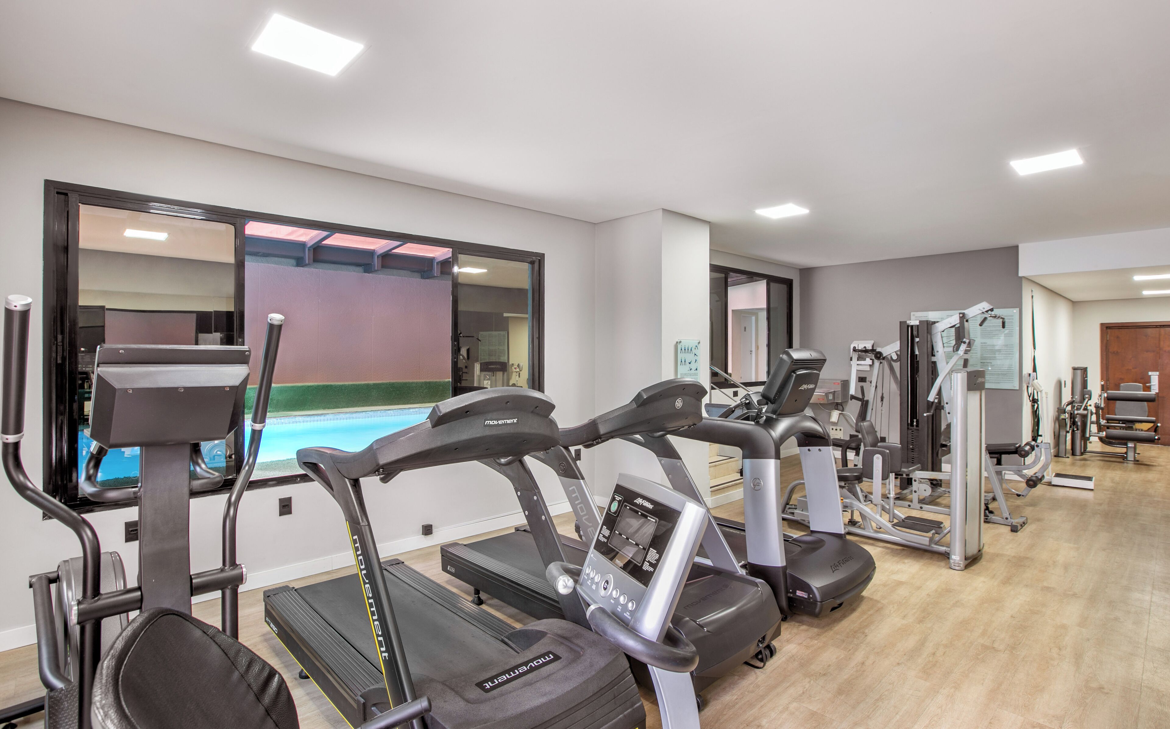 Academia com esteiras, elípticos e equipamentos de musculação.