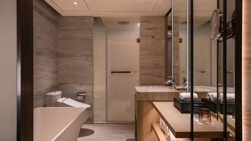 A modern bathroom with a freestanding bathtub, a vanity with a mirror, and a shower area.