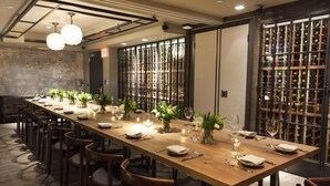 A long dining table set with chairs, wine glasses, and small potted plants. - Park South Hotel, part of JdV by Hyatt (New York)