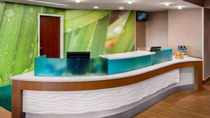 A reception desk with a green leaf mural, a wooden counter, and a white cloth-covered area. - Willow Grove Inn (Willow Grove)