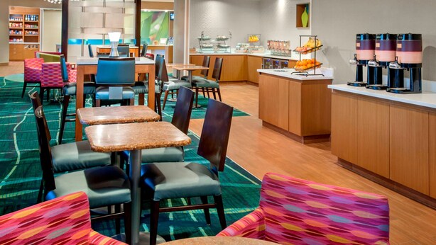 A hotel lobby with multiple seating areas, a buffet counter, and a coffee station. - Willow Grove Inn (Willow Grove)