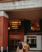 A hotel entrance with a sign reading 'AC HOTELVIEUX - MONTRÉAL' and the number '445' on the wall.