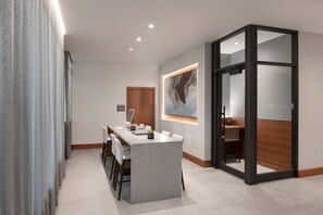 A modern dining area with a central island, a wooden door, and a large abstract painting on the wall. - AC Hotel by Marriott Old Montreal (Montreal)