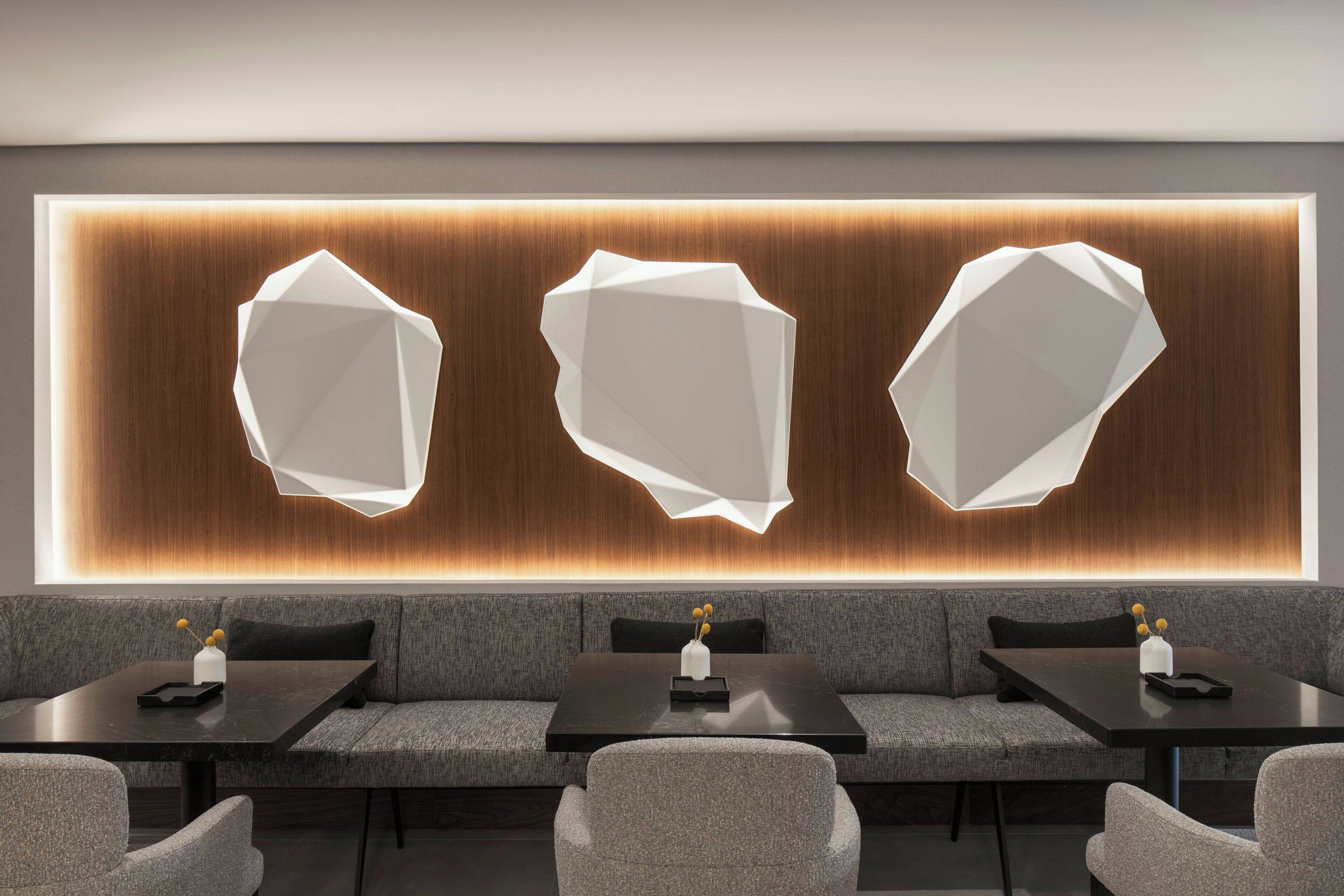 A modern lounge area with a long table and multiple seating options, including sofas and chairs.