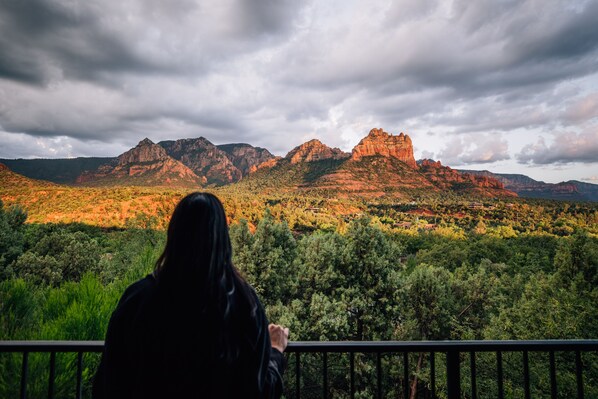 A person overlooking a mountainous landscape with dense green vegetation and rocky formations.
