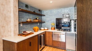 Una cocina compacta con armarios de madera, lavavajillas integrado y cafetera.