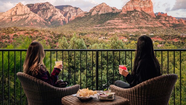 Two people sitting on wicker chairs on a balcony with a view of red rock formations. - The Cliffs (Sedona)