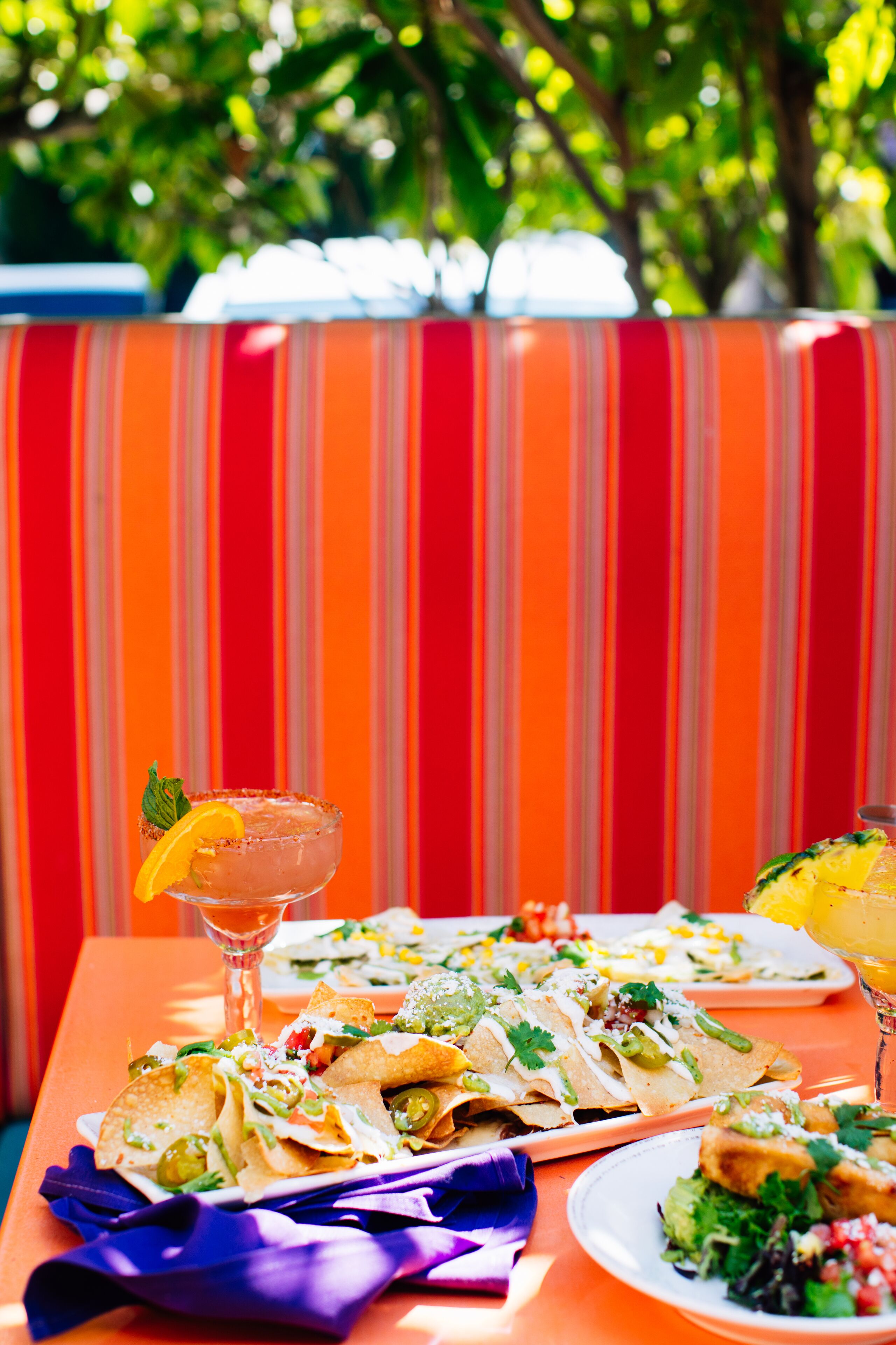A table with food and drinks, set against a striped background.