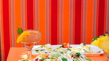 A table with food and drinks, set against a striped background.