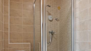 Un baño con ducha de vidrio, inodoro y lavamanos.