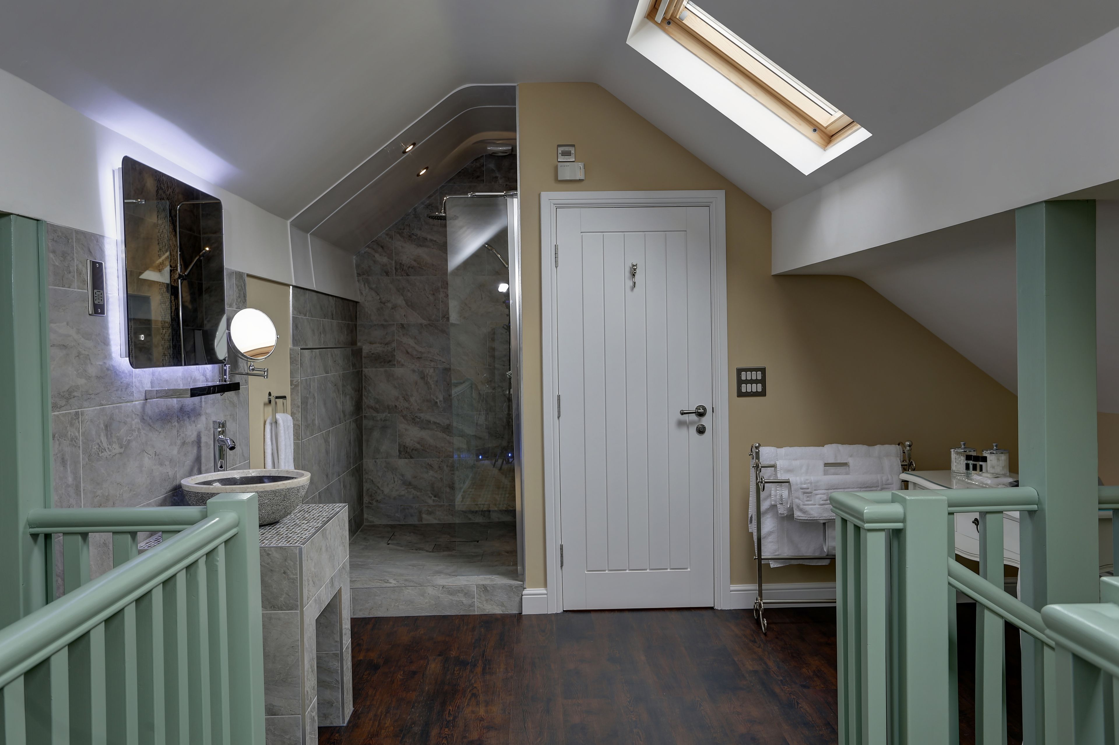 Un bagno con lavabo in pietra, uno specchio, una doccia e una porta.