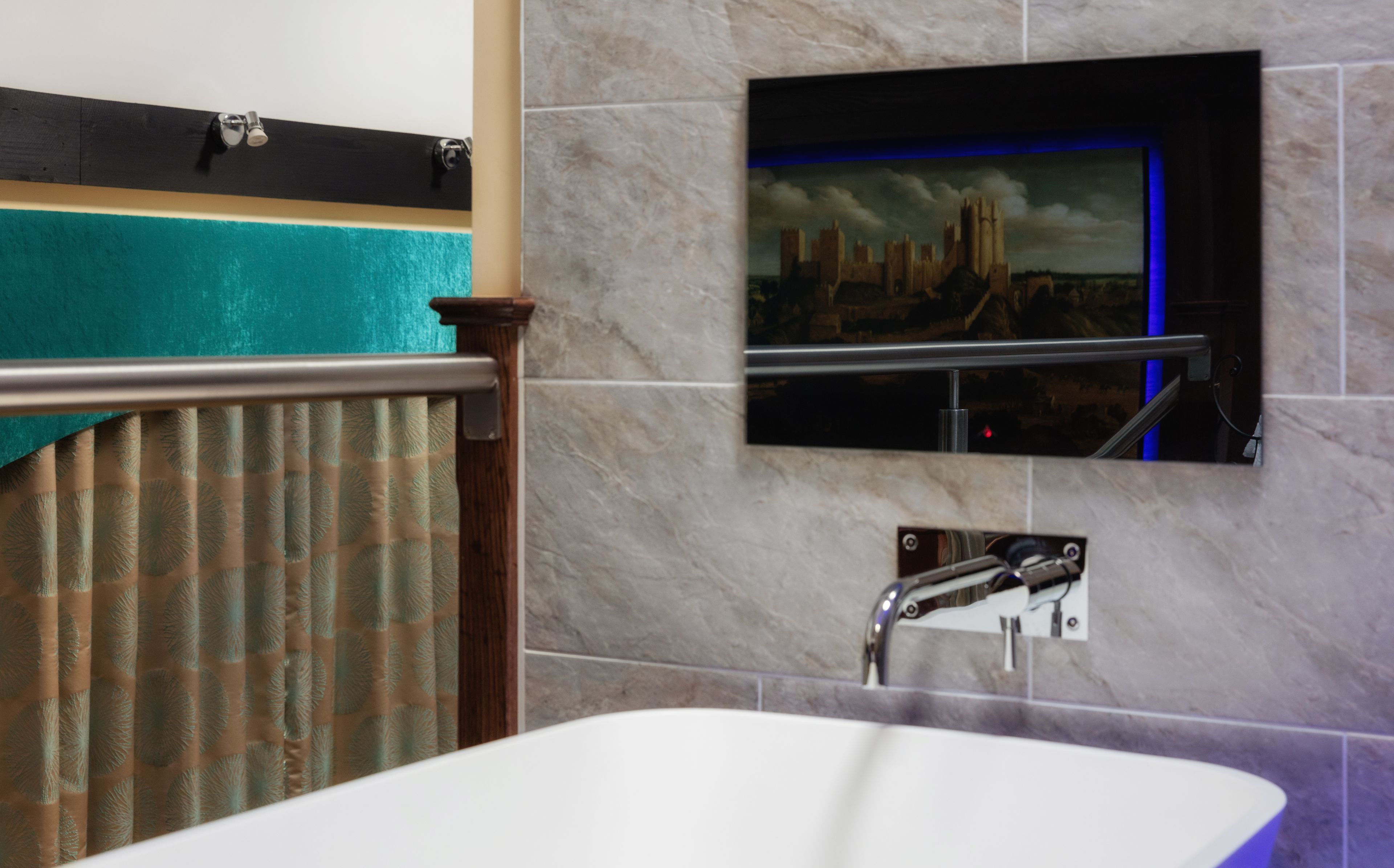 A bathroom with a bathtub, a towel rack, a mirror, and a wall-mounted light fixture.
