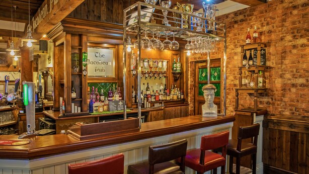 A bar area with wooden decor, a bar counter, and multiple seating options.