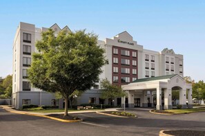 Welcome to Hyatt Place, a hotel with a symmetrical design and central entrance pavilion, set amidst a beautifully landscaped area with mature trees.