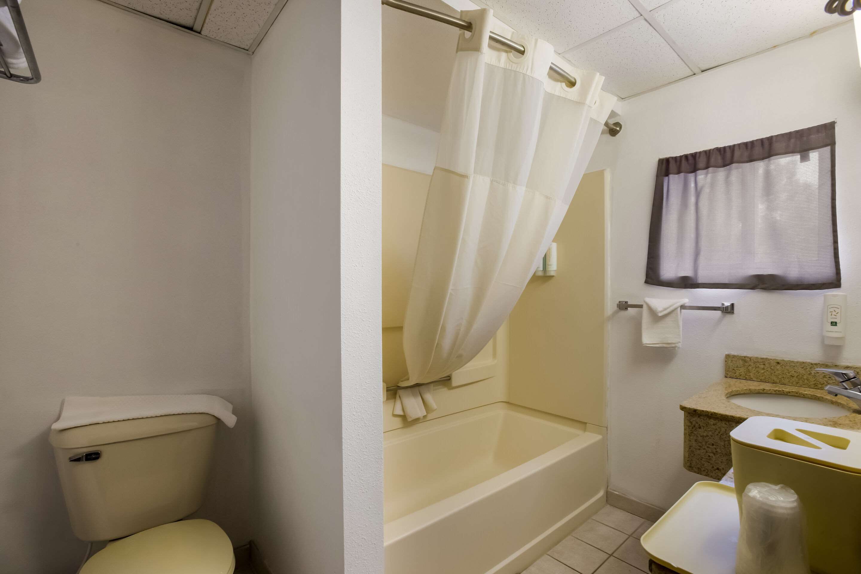 A bathroom with a toilet, a bathtub, and a sink.