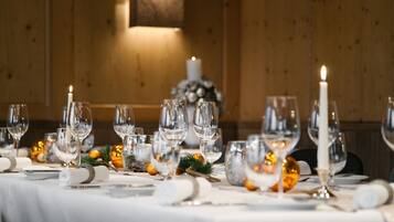 A table set for a formal dinner with multiple wine glasses, plates, and a candle.