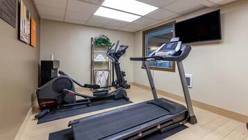 Ein Fitnessraum mit Laufbändern, einem Ergometer und einer Gewichtbank.