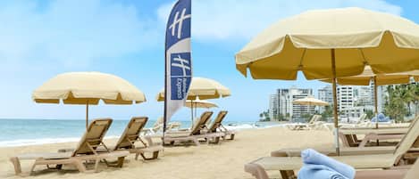 In Strandnähe, Liegestühle, Sonnenschirme, Strandtücher