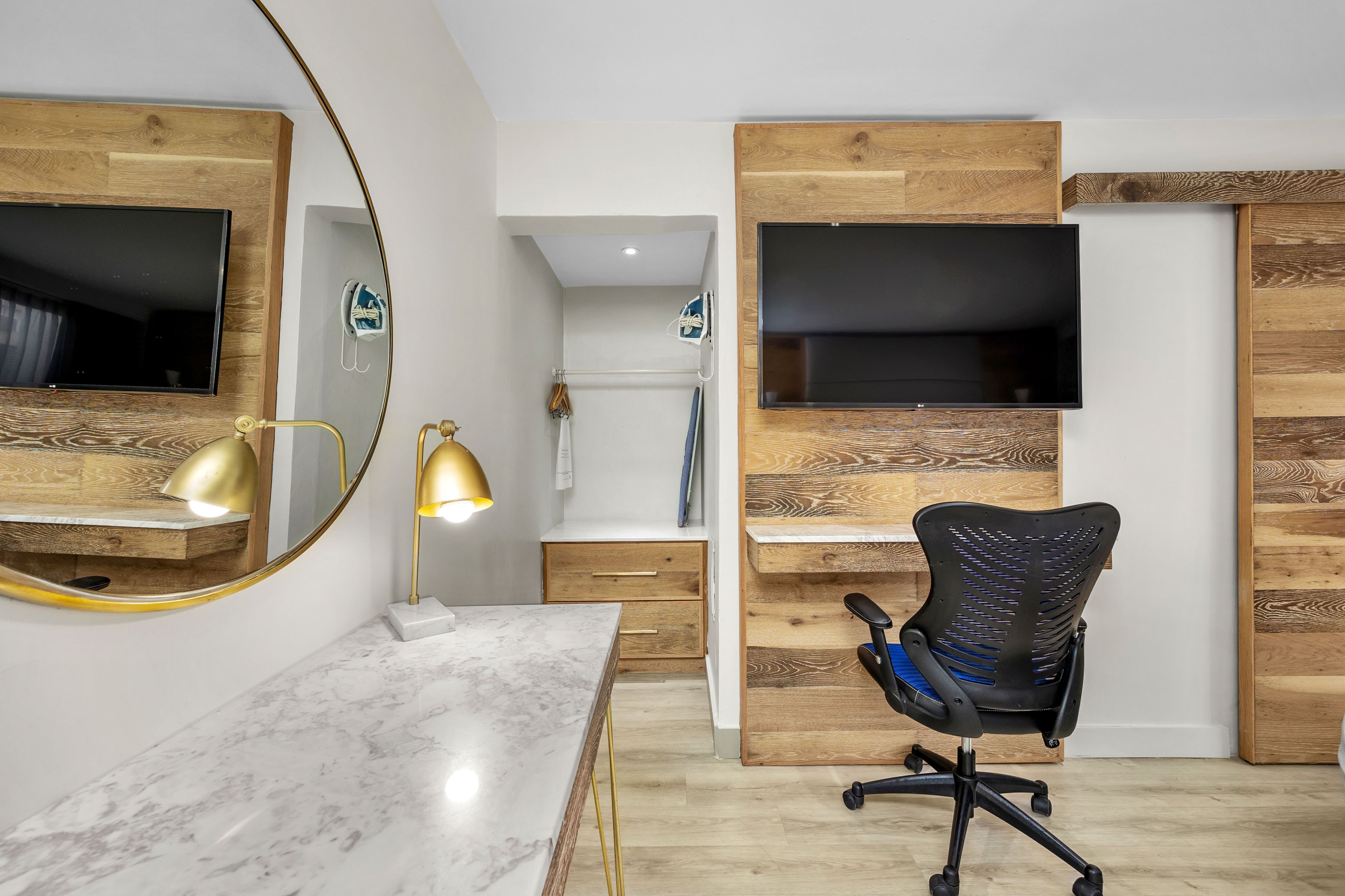 A modern office space with a marble desk, black office chair, and wooden panel walls.