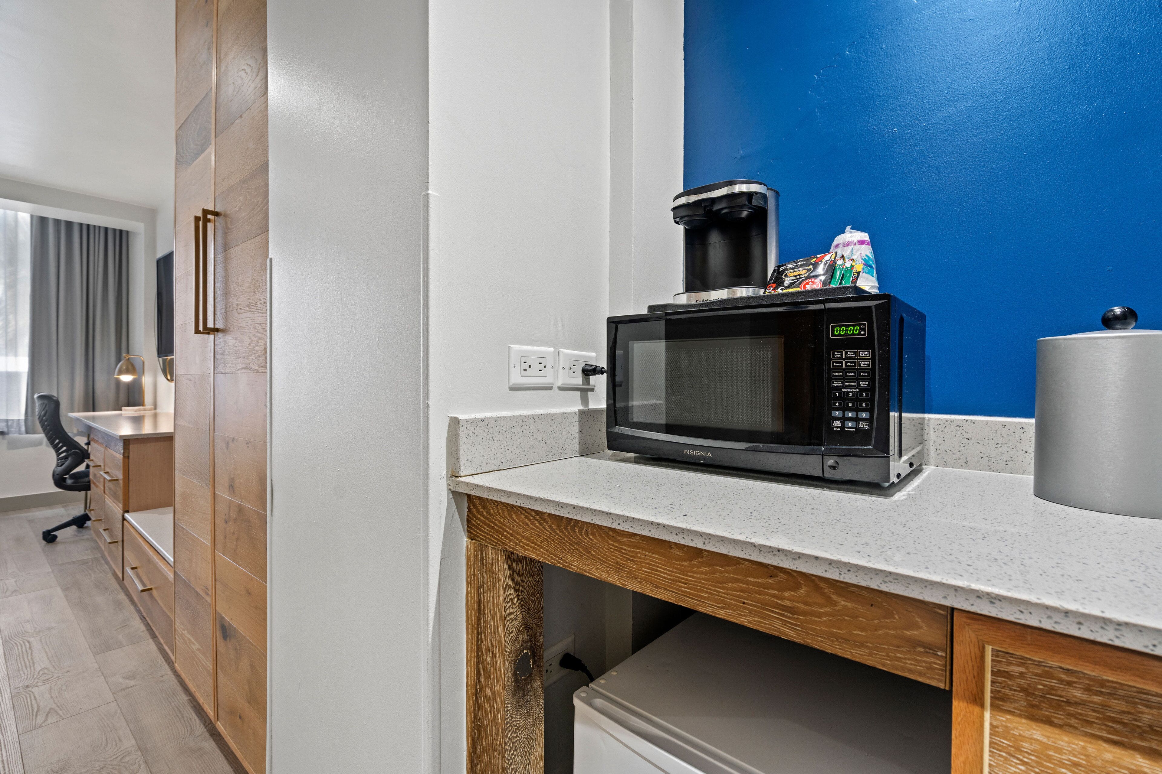 A kitchenette with a microwave, coffee maker, and a small refrigerator.
