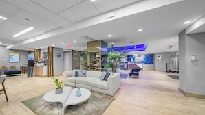 A modern lobby with a reception desk, seating area, and a blue accent wall. - Holiday Inn Express San Juan Condado by IHG (San Juan)