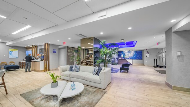 A modern lobby with a reception desk, seating area, and a blue accent wall. - Holiday Inn Express San Juan Condado by IHG (San Juan)
