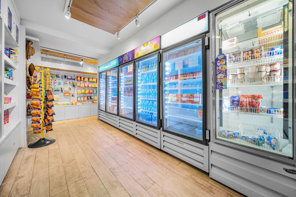 Een supermarkt met koelvitrines en schappen vol snacks.
