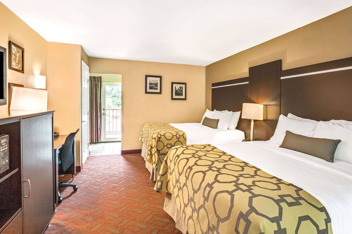 Une chambre d’hôtel avec deux lits, un bureau et une chaise.