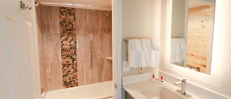 A bathroom with a bathtub, a sink, and a shower.
