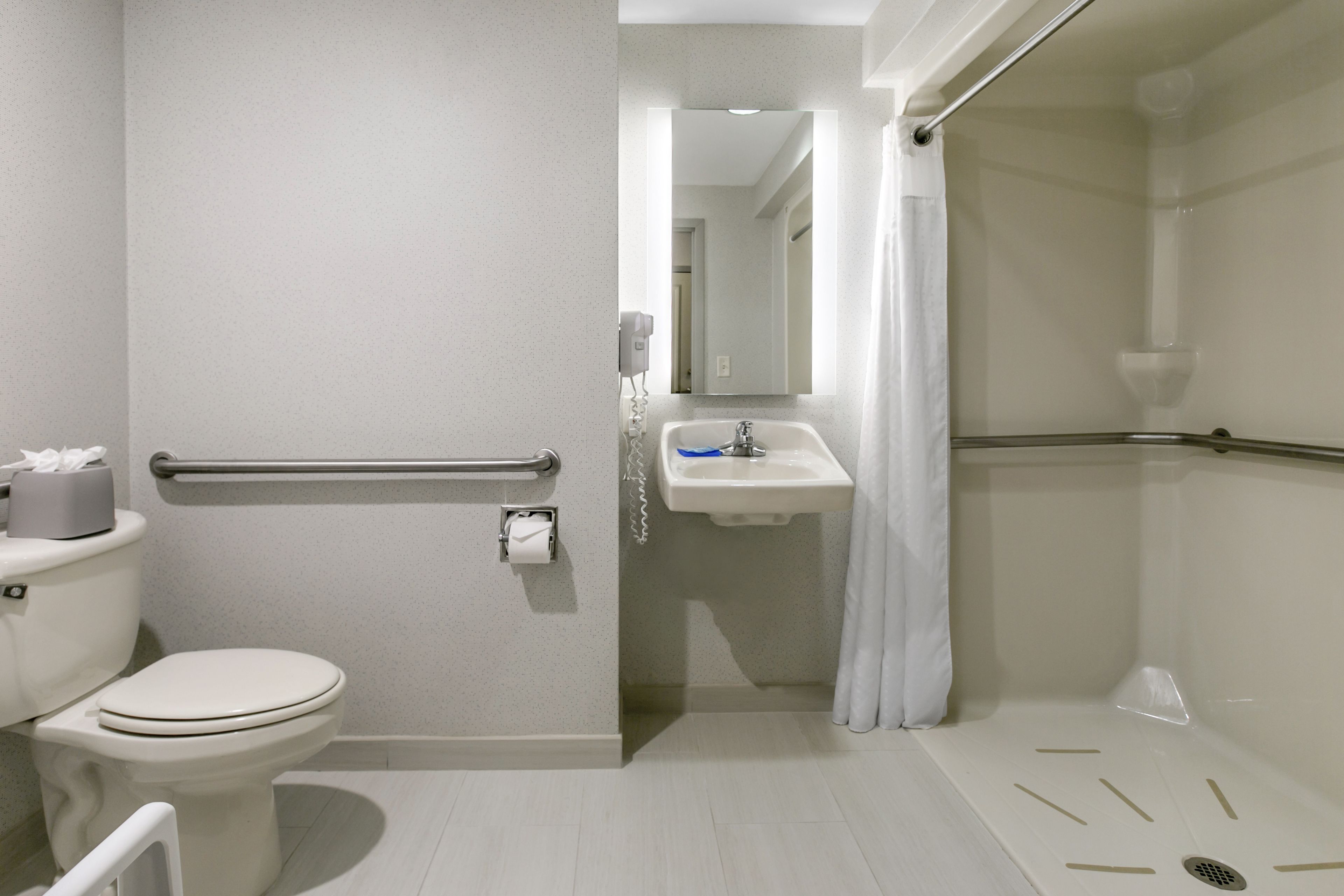 A modern bathroom with a toilet, sink, and shower area.
