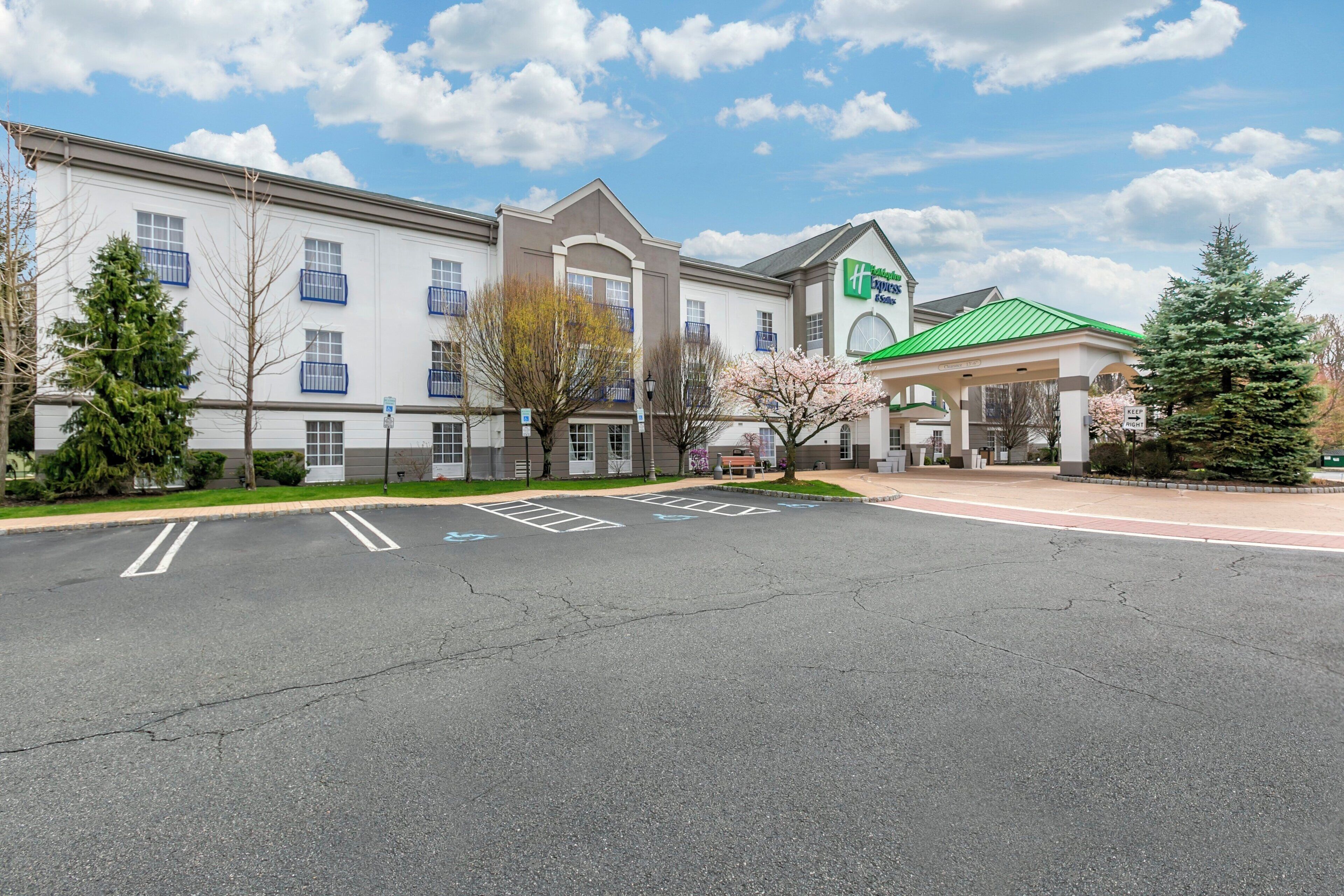 A hotel with a parking lot, a green-roofed building, and a Holiday Inn Express sign.