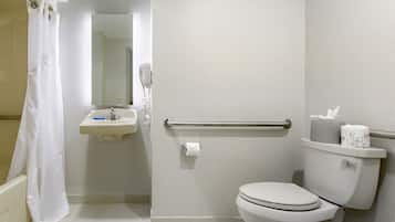 A bathroom with a toilet, sink, and shower area.