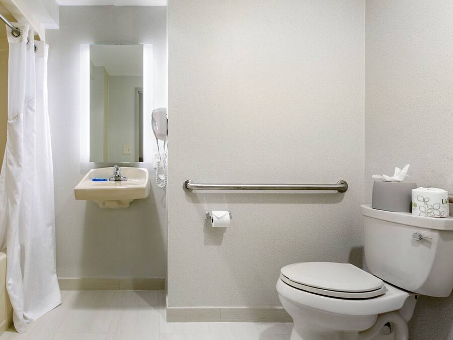A bathroom with a toilet, sink, and shower curtain.