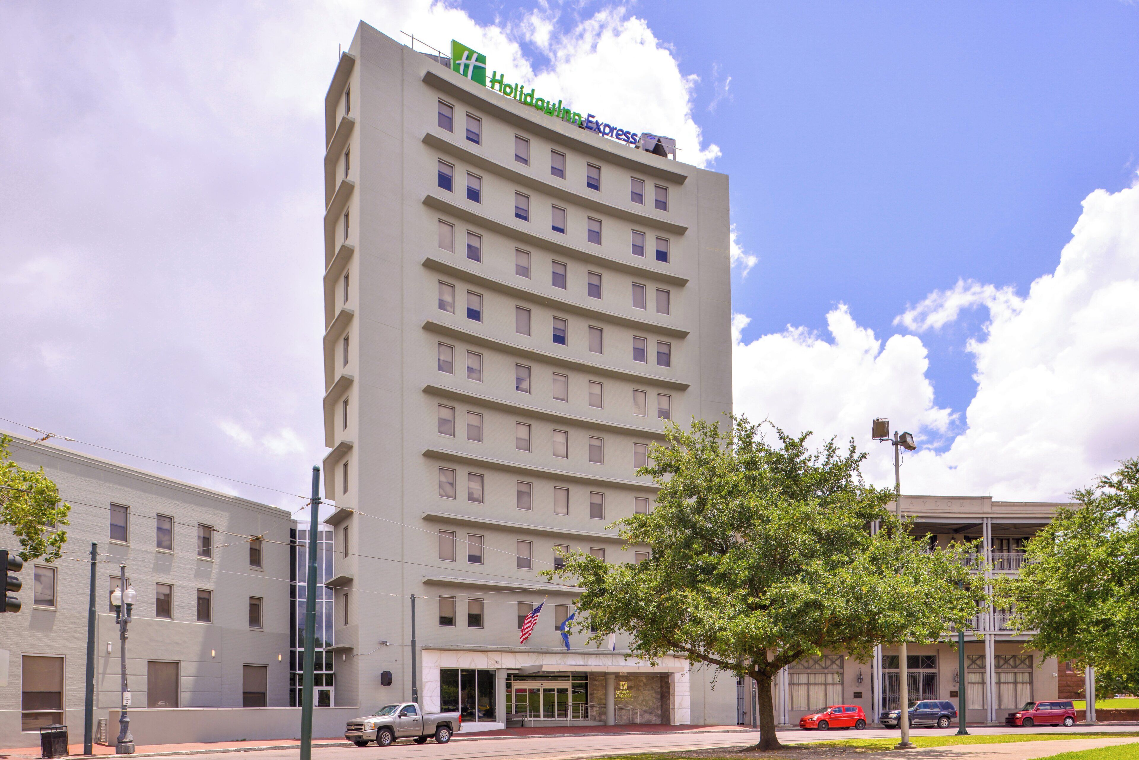 A multi-story hotel with a flat facade, a visible entrance, and a flag.