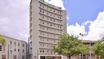 A multi-story hotel with a flat facade, a visible entrance, and a flag.