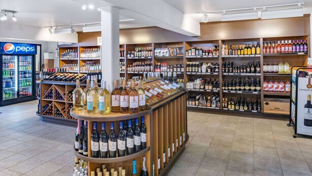A liquor store with shelves of various alcoholic beverages and a Pepsi refrigerator.