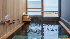Una sauna de madera con vista al mar a través de un amplio ventanal.