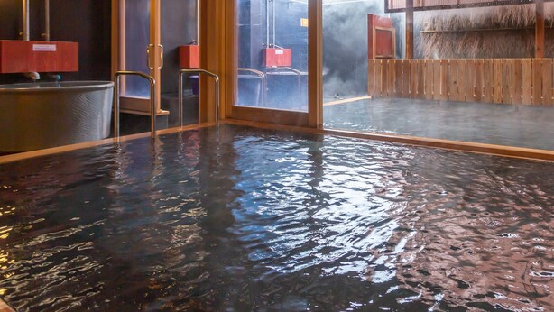 Un baño de aguas termales con barandillas de madera y vistas al exterior.
